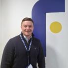 Fraikin employee stood in front of company logo