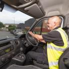 Driver in high visibility jacket driving van