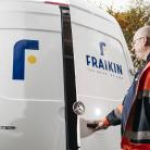 Man in orange high visibility jacket opens the rear door of a white Sprinter van, displaying the Fraikin logo