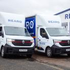 Two Rearo branded vans, parked outside a Rearo shop.