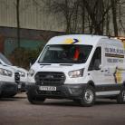 White liveried transit van, parked in a car park with three other similarly liveried vans