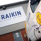A Fraikin electric vehicle is parked at a charging station beside a building. The building features a large Fraikin sign with the tagline "You drive. We care." The vehicle displays text about being 100% electric with zero emissions.