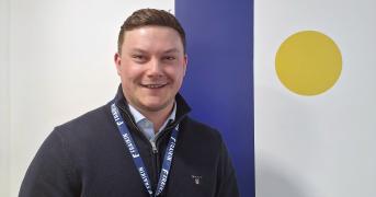 Fraikin employee stood in front of company logo
