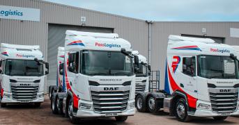 Four Pass Logistics branded 6x2 tractor units parked in two rows in front of a warehouse.