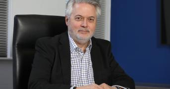 Man in a suit sat at a desk