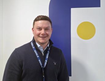 Fraikin employee stood in front of company logo