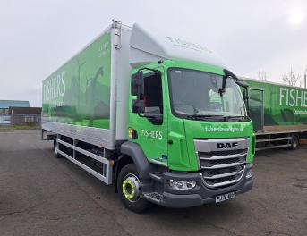 A green and white Fishers laundry service truck parked outdoors. The truck features the company's logo and website, fisherslaundry.co.uk, on its side along with an image of a stag.