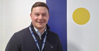 Fraikin employee stood in front of company logo