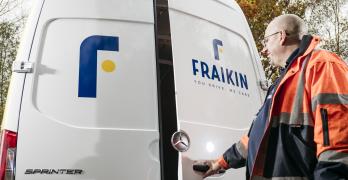 Man in orange high visibility jacket opens the rear door of a white Sprinter van, displaying the Fraikin logo