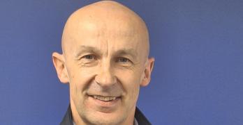 Headshot of a man in front of a purple background
