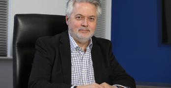 Man in a suit sat at a desk